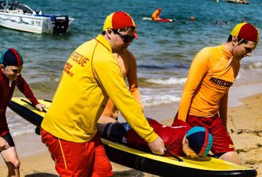 Surf lifesavers assisting with rescue training on the beach